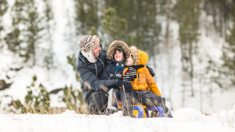 Family having winter fun sliding on show