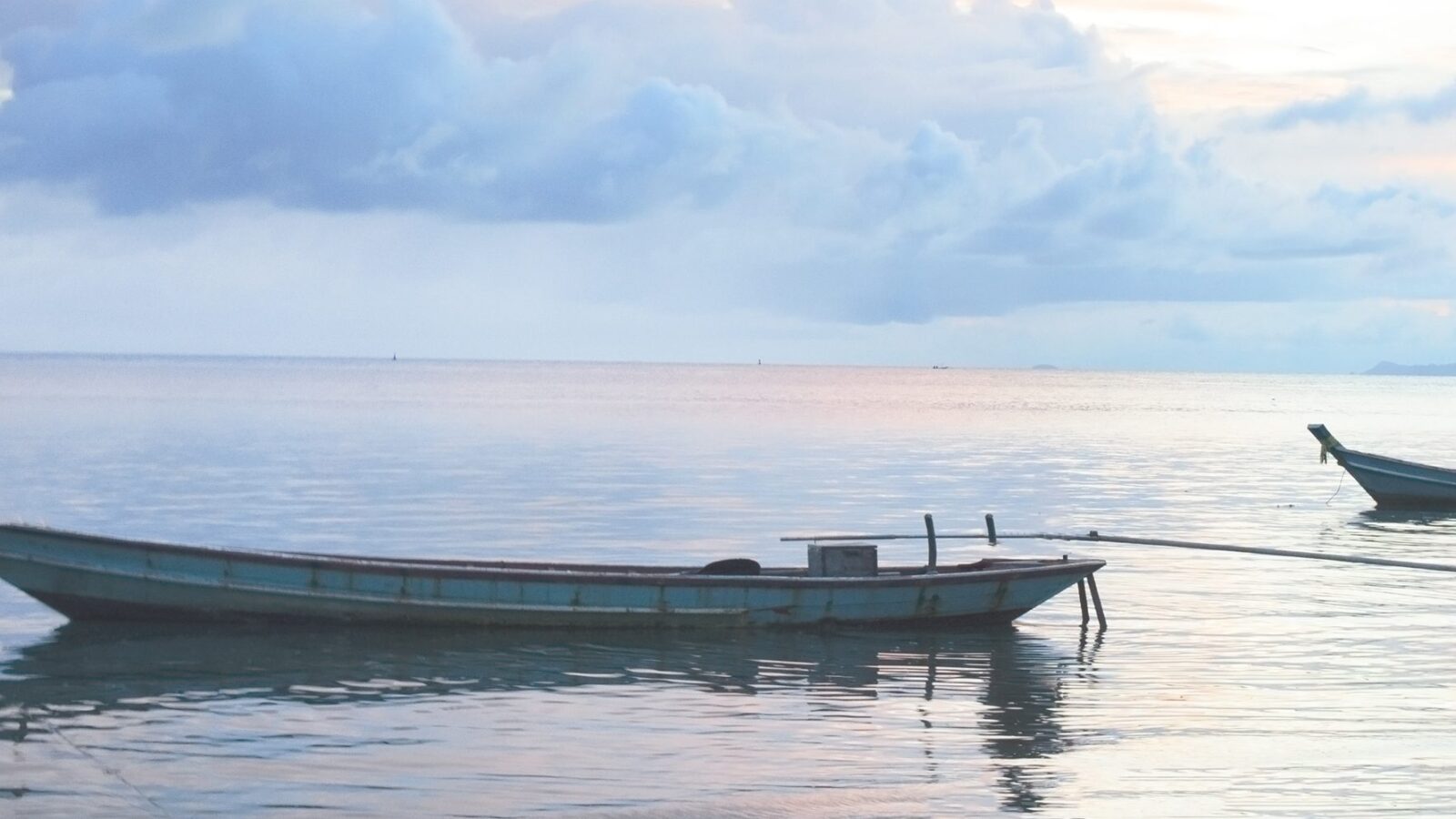 Traditional wooden boats resting on calm water during luxury Bali vacations.