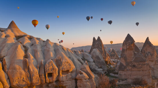 Hot Air Balloons rise up over the Goreme Valley in Cappadocia, Turkey