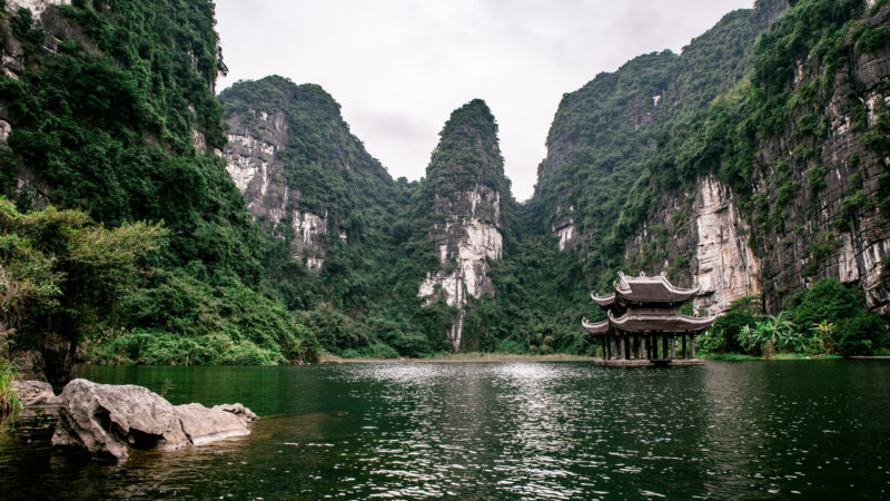 Boat cave tour in Trang An Scenic Landscape formed by karst towers and plants along the river (UNESCO World Heritage Site). It’s Halong Bay on land of Vietnam. Ninh Binh province, Vietnam.