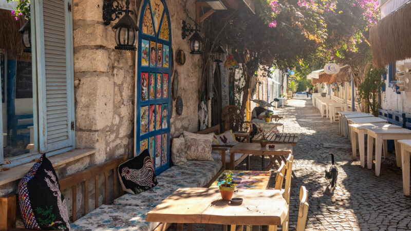 Picturesque street in Mediterranean Alacati Town in Turkey. Alacati is popular historical tourists destination in Turkey. Cozy outdoor cafe and restaurants
