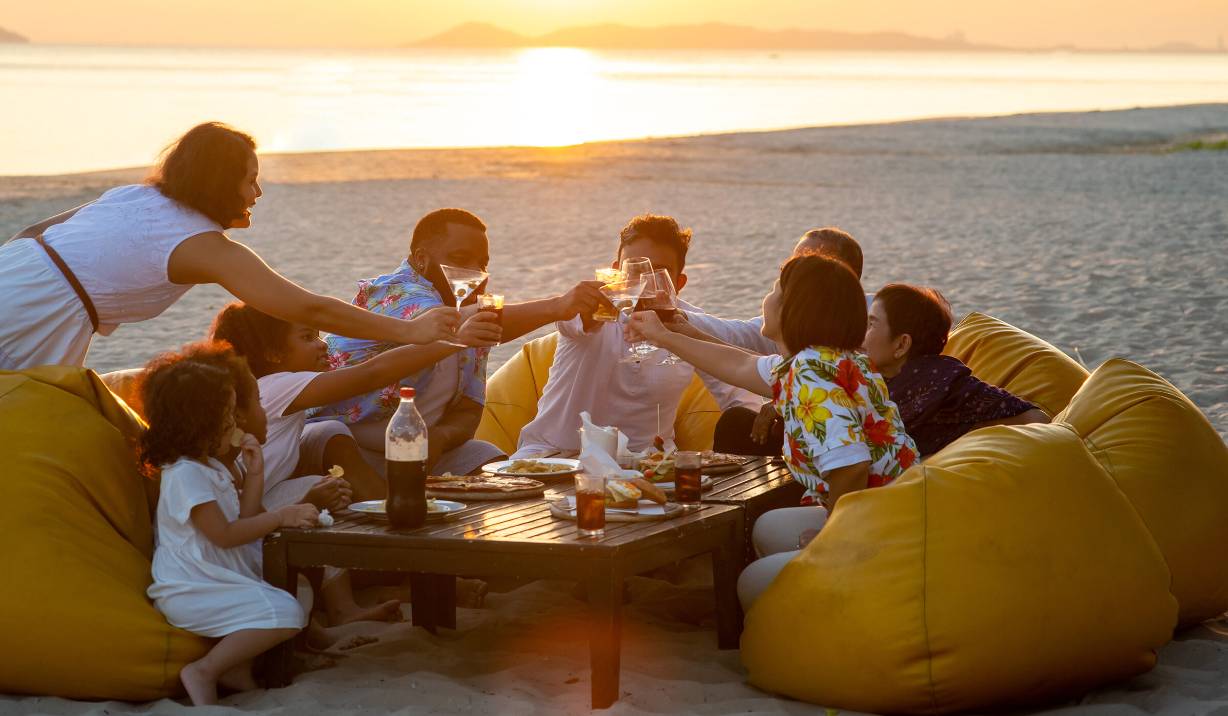 A group toast at a beach dinner during luxury special occasion tours.