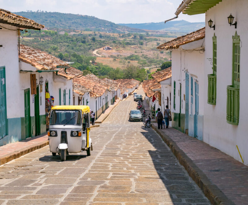 Barichara, Colombia, Santander, colonial street with white historic buildings and taxi
