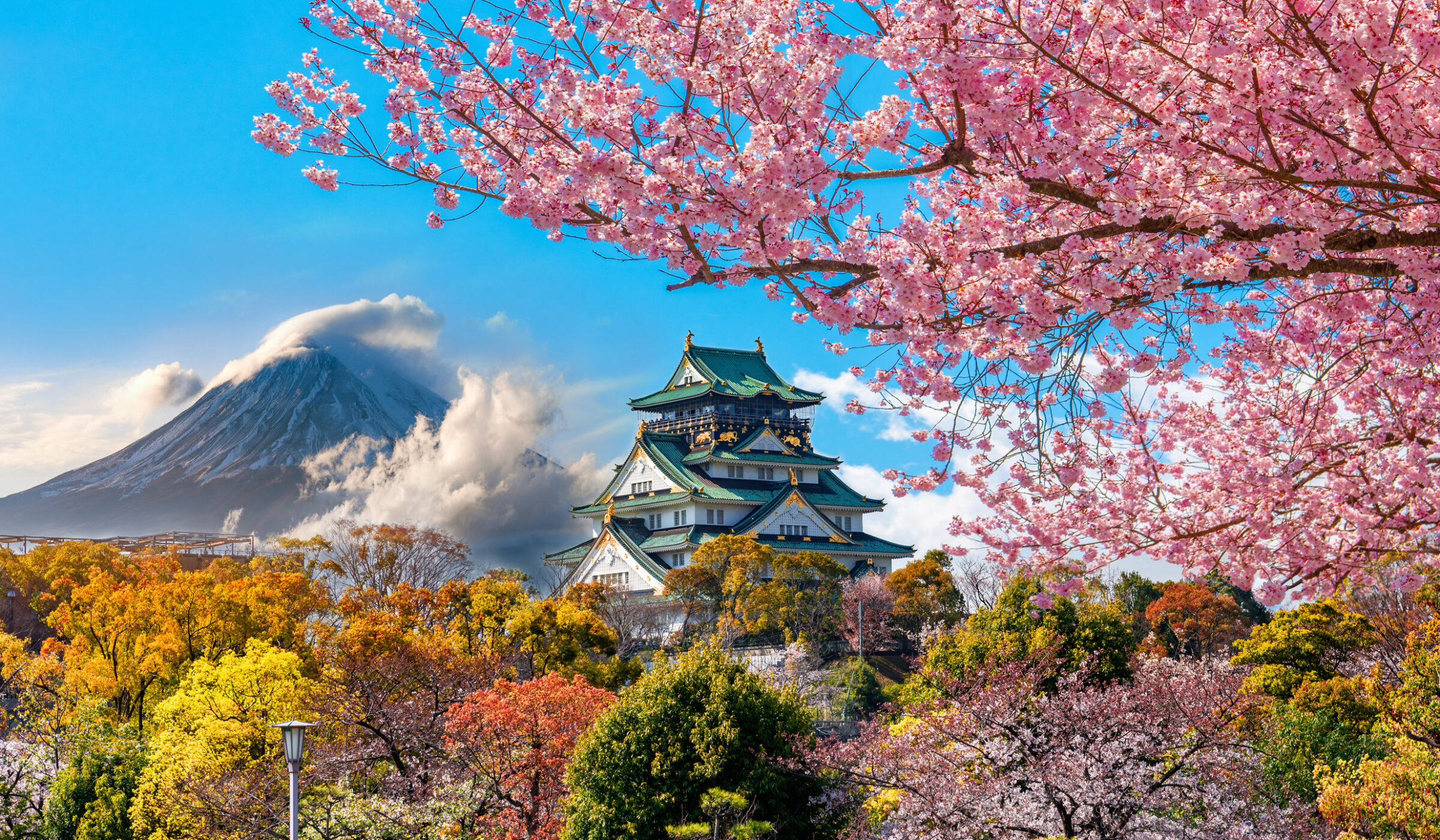 Osaka Castle surrounded by autumn colors and cherry blossoms with Mount Fuji in the background during luxury family vacations to Japan.
