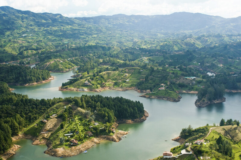 Aerial view of the Guatapé Reservoir with its irregular shorelines, islands, green hills, and patches of development surrounding the water as part of Luxury Colombia Trips.