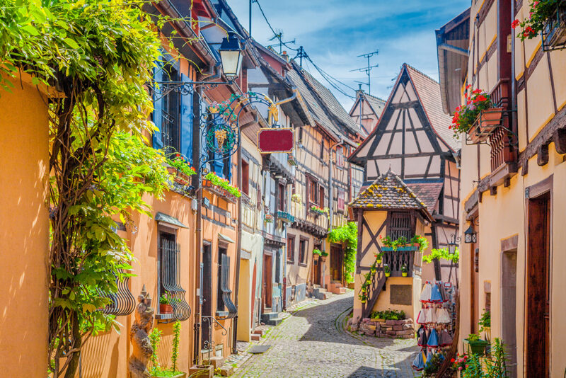 A charming cobblestone street with traditional half-timbered houses on luxury France tours.