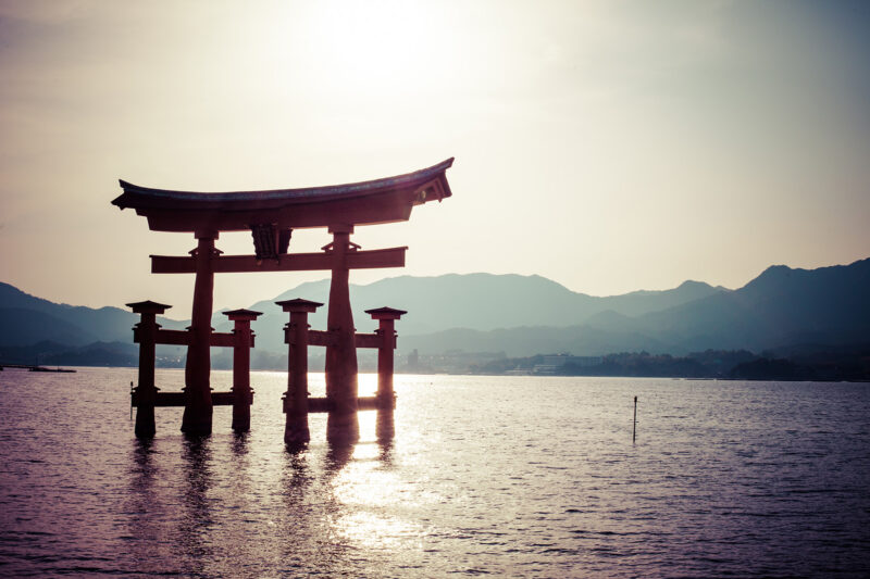 Private Japan Luxury Tours - Miyajima, Famous big Shinto torii standing in the water in a bay , with misty mountains in the background in Hiroshima, Japan