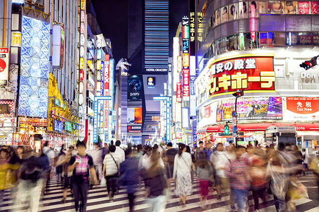 Private Japan Luxury Tours - Crowd of People Crossing big zebra crossing at night, lit by neon signs in Tokyo, Japan