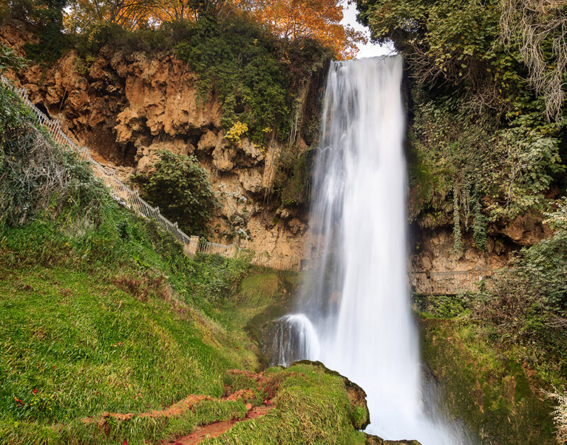Luxury Greece Tours - Cascading tall waterfall surrounded by atumn foliage