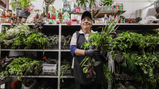 Quito local surrounded by their fresh local produce, Ecuador