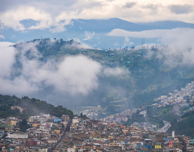 Scenic view of misty hills overlooking the city of Quito during luxury Ecuador vacations.