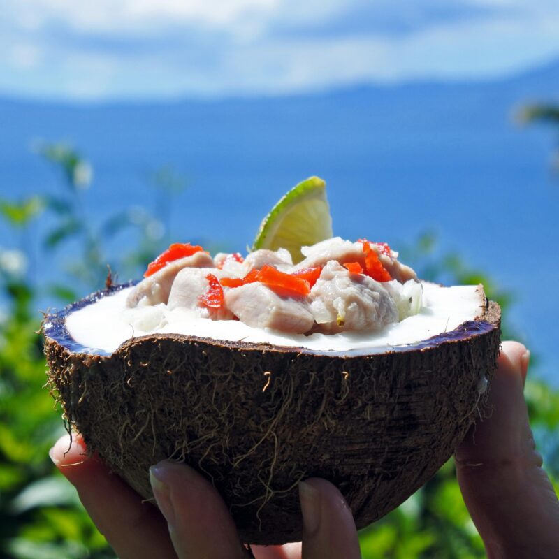 Raw fish salad served in a coconut shell with lime and peppers during luxury South Pacific vacations.