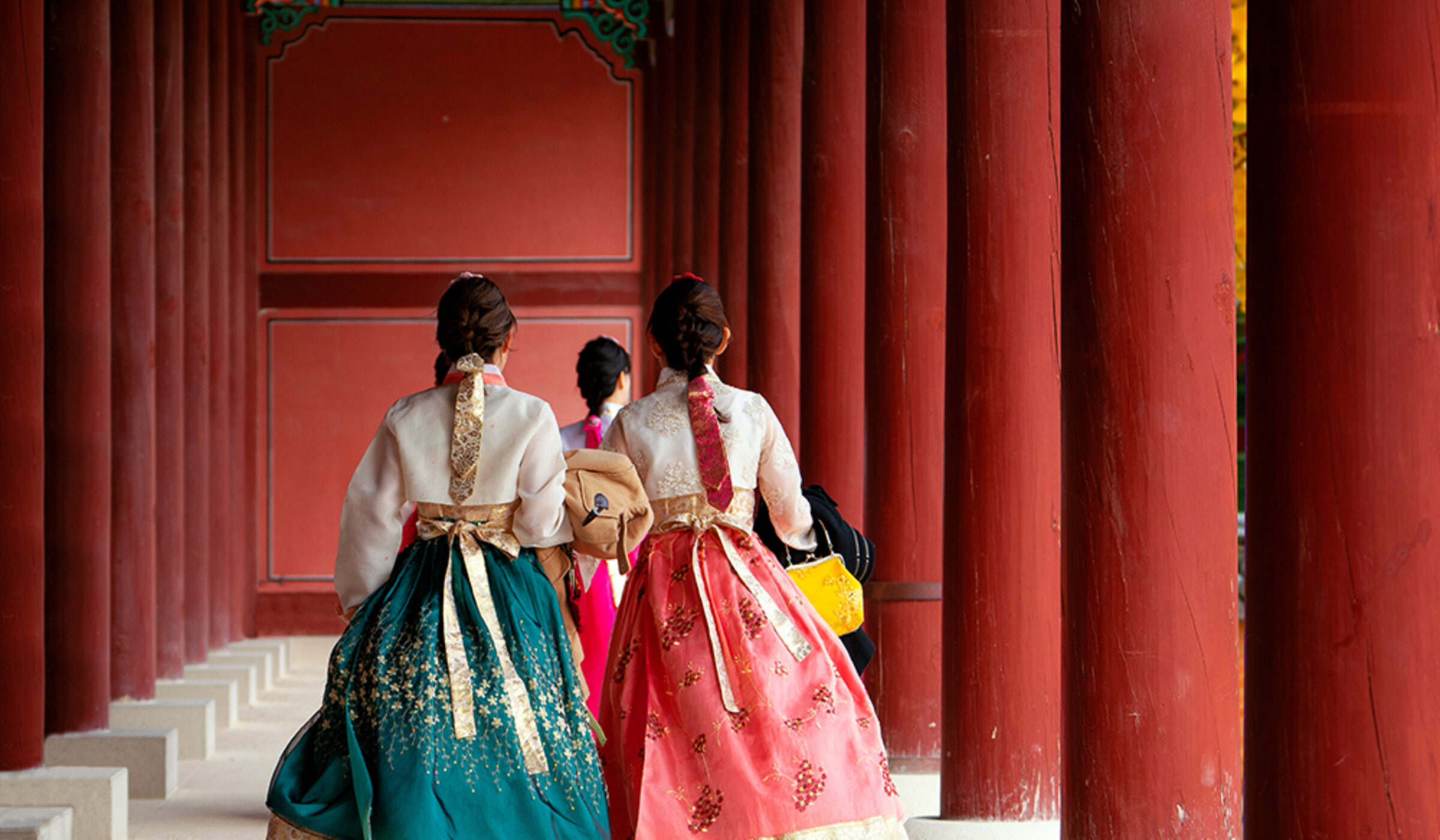 Women in traditional Hanbok walking through a palace during luxury South Korea trips.