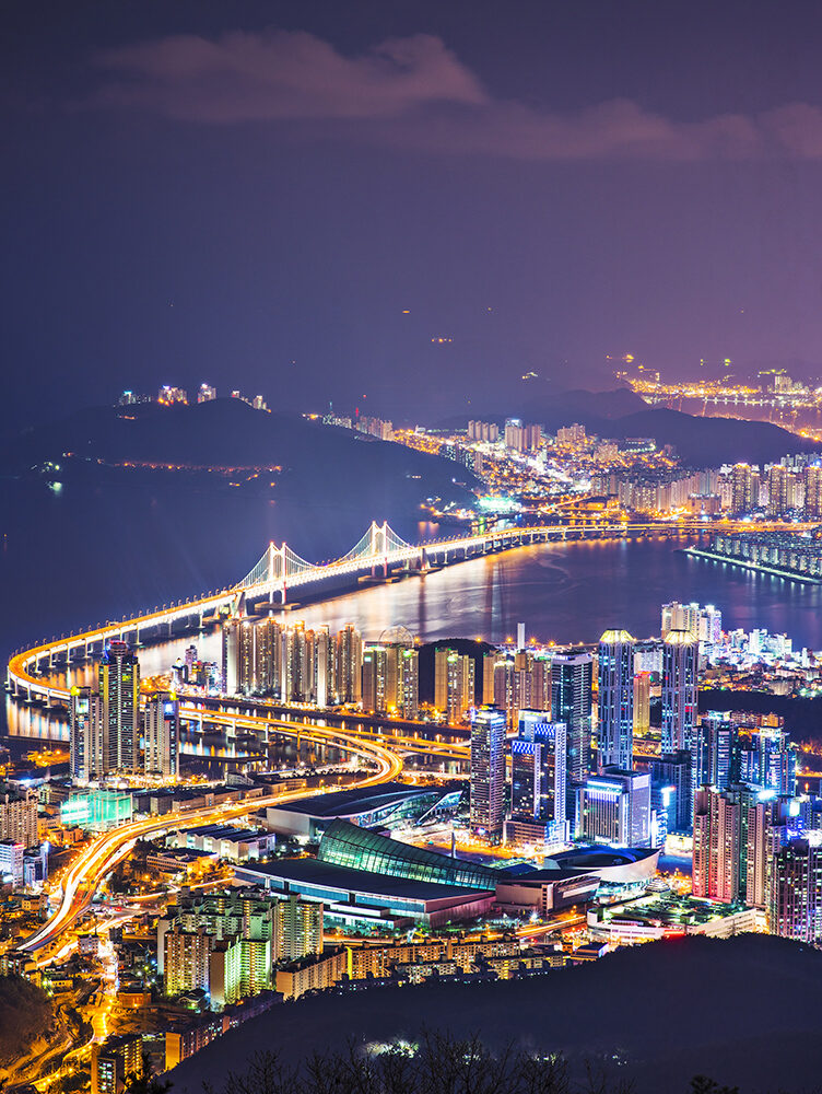 Nighttime view of a brightly lit bridge and city skyline on luxury South Korea vacations.