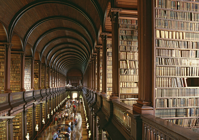 The Long Room library in Trinity College Dublin, an immense hall with a barrel-vaulted ceiling and two floors of tall wooden bookshelves. Include it in your luxury Ireland holidays.