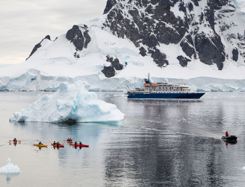 Sea kayaks and expedition cruise ship MV Sea Spirit (Poseidon Expeditions) with iceberg, Orne Harbor, Graham Land, Antarctic Peninsula, Antarctica Boat, Human, Ice, Mountain, Nature, Outdoors, Person, Snow, Transportation, Vehicle
