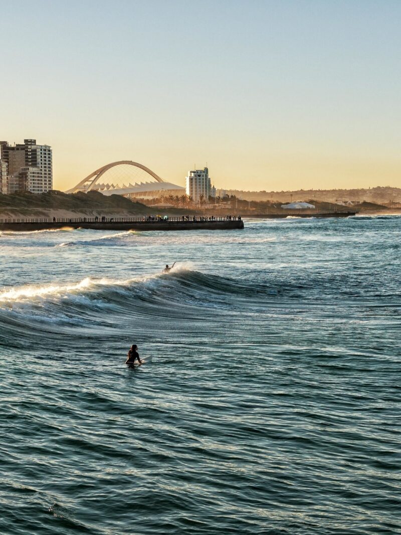 Surfers Enjoying the Waves During Sunset in Durban, South Africa