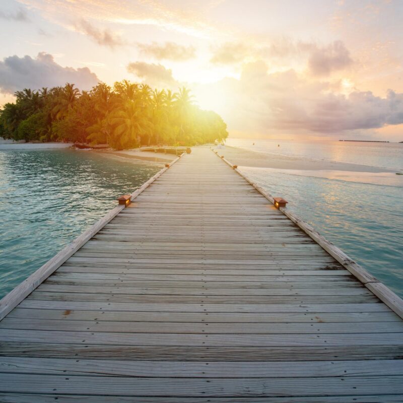 Wooden walkway into resort at Maldive, sun glare from sunset time 1125668320