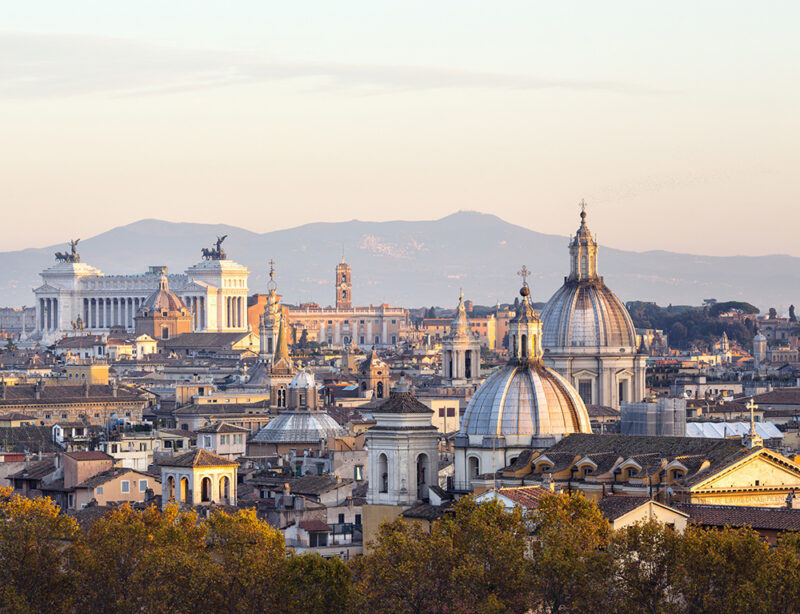 The sun sets over the cityscape of Rome in Italy.
