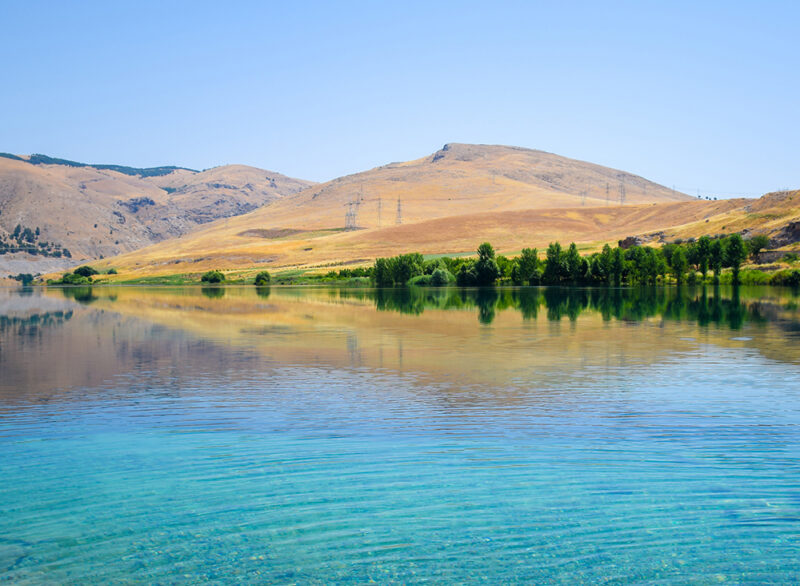 Clear crystal blue water on the Euphrates river near the Ataturk Ataturk, Dam, Euphrates, River, Turkey, Nature, Sanliurfa, Urfa, Landscape, Province, Adiyaman, Summer, Anatolia, Water, Waterfront, Riverfront, Riverside, Blue, Mountain, Hill, Horizontal, Ancient, Asia, Eastern, Sky, Scenic, Turkish, Destination, Crystal, Clear, Lake, Nature, Outdoors, Water Clear crystal blue water on the Euphrates river near the Ataturk dam with the mountains or hills as a background.Ataturk, Dam, Euphrates, River, Turkey, Nature, Sanliurfa, Urfa, Landscape, Province, Adiyaman, Province, Summer, Anatolia, Water, Waterfront, Riverfront, Riverside, Blue, Mountain, Hill, Horizontal, Ancient, Asia, Eastern, Sky, Scenic, Turkish, Destination, Crystal, Clear
