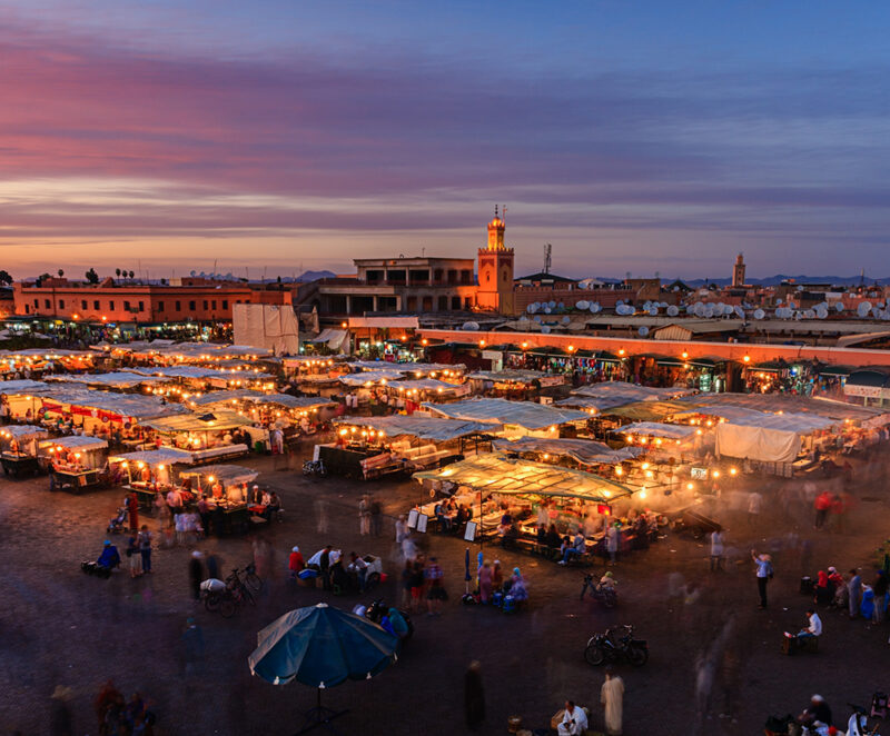 Dusk settles over Jemaa el-Fnaa square in Marrakech – market stalls light up beneath a twilight sky.