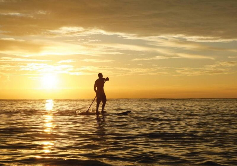 A paddleboarder silhouetted against the setting sun off Desroches Island in the Seychelles.