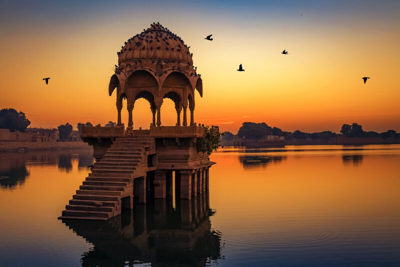 A historic domed pavilion on a calm lake at sunset for luxury history tours.