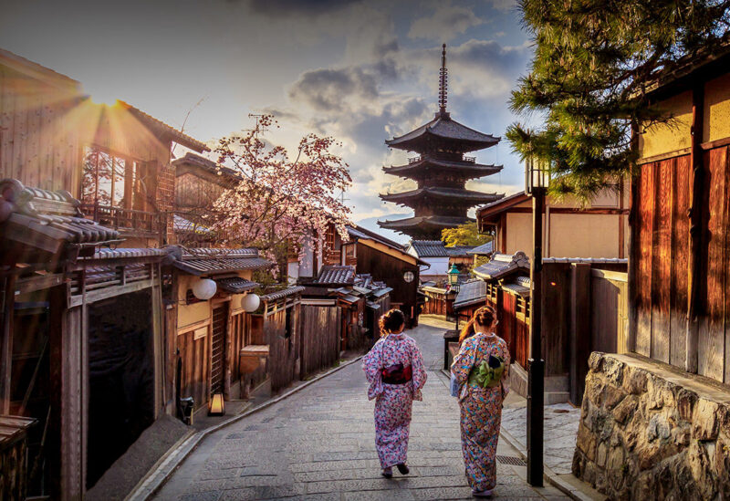 A scenic street view of traditional Japanese architecture and a pagoda during luxury history tours.