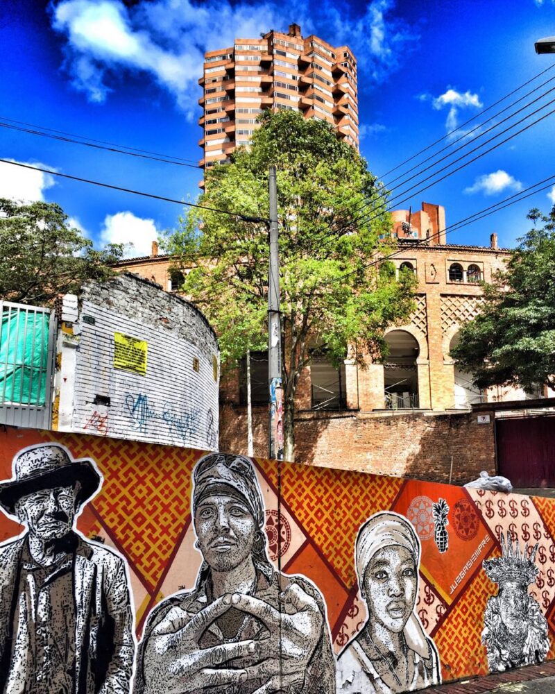 Colorful urban mural of faces in a city for luxury art tours.