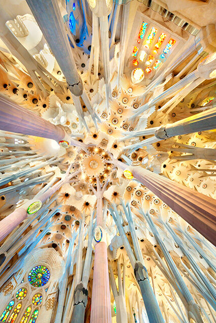 Looking up at the geometric stone ceiling and columns of a cathedral for luxury art tours.