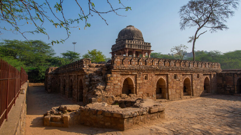 Ancient stone arches and a dome in Mehrauli Archaeological Park – centuries of Delhi's history.