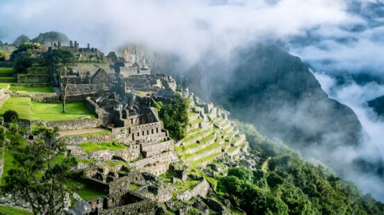 Ancient Inca village set in the mountains of Peru, surrounded by rolling clouds