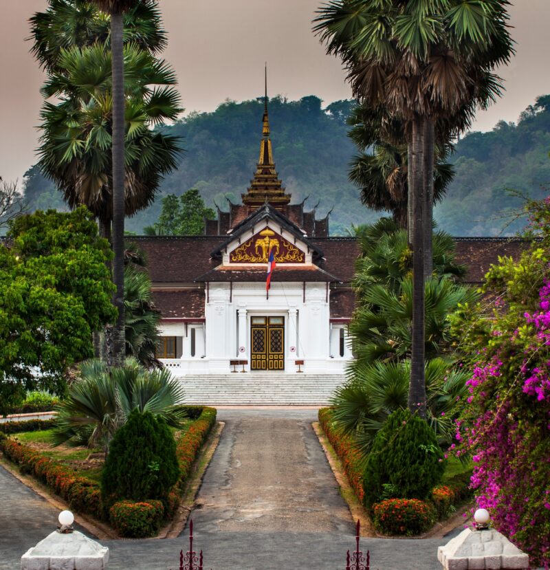 The white and gold facade of the Royal Palace Museum in Luang Prabang during luxury Laos holidays.