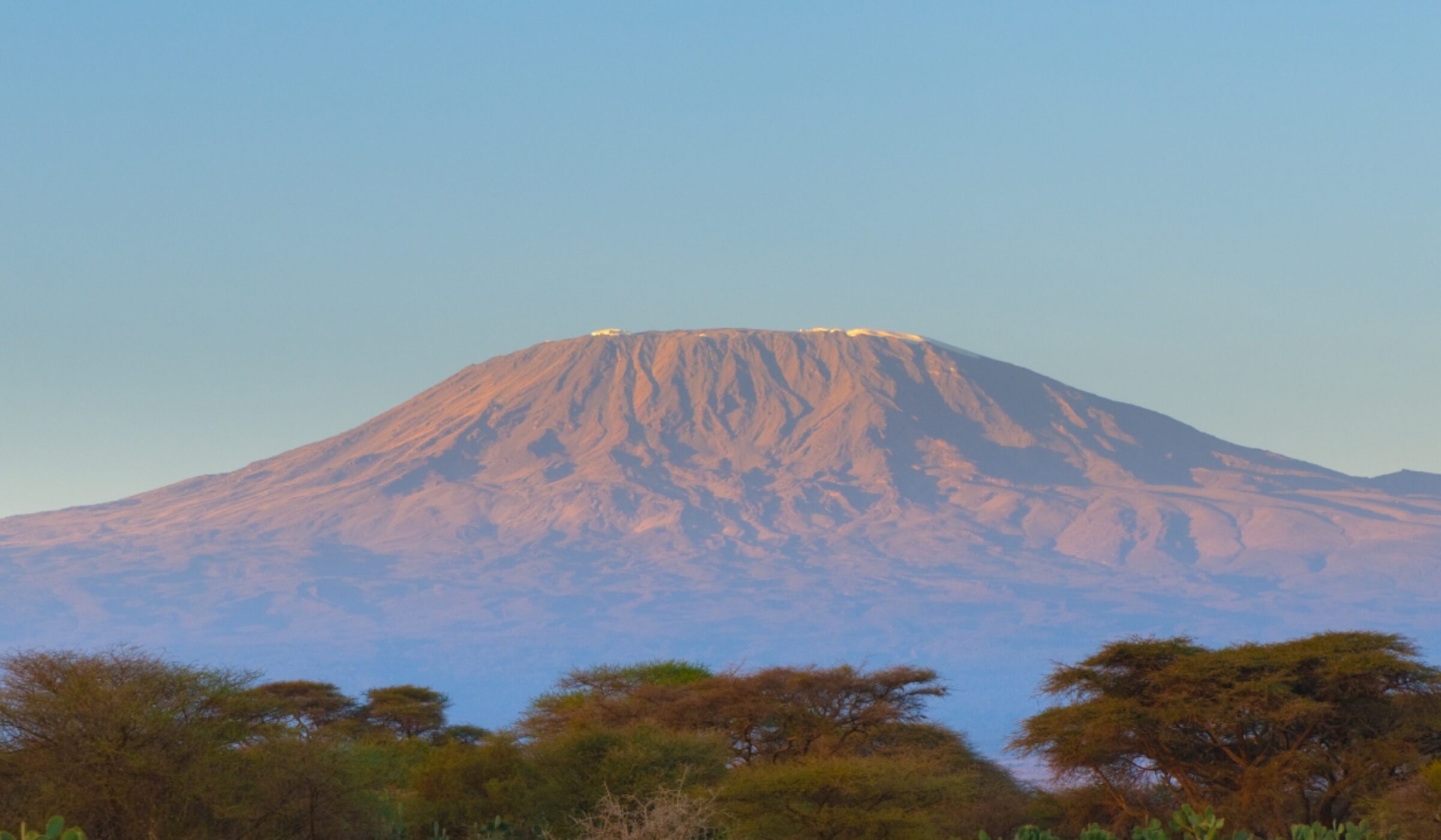 Amboseli National Park, Tanzania, at sunset with Mount Kilimanjaro peaking through the clouds