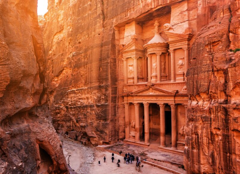 Sunlight hits the towering cliffs framing Petra's Treasury in Jordan.