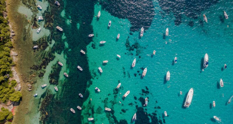 Plendy of yachts or boats i the middle of summer day with sunshine and greenish blue meidterranean sea