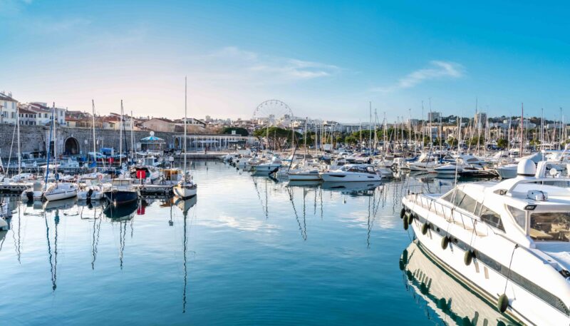 Yachts and sailboats moored in Antibes marina on a blue water – French Riviera, Cote D Azur, France – Summer vacation concept.