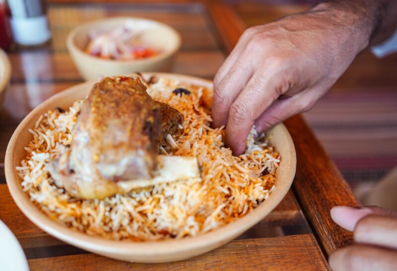 Man eating using hand a traditional biryani rice and chicken dish in local restaurant oman, nizwa, middle east, gulf, arab, arabic, arabian, city, tourist destination, destination, vacation, holiday, highlight, tourism, travel, Idyllic, inspirational, travelling, Local life, local experience, authentic, genuine, editorial, documentary, everyday life, real life, lifestyle, social, society, culture, people, Man, eating, using, hand, traditional, biryani, rice, chicken, dish, local, restaurant, using hand, delicious, tasty, food, male, adult, detail, close up Man eating using hand a traditional biryani rice and chicken dish in local restaurant, Oman
