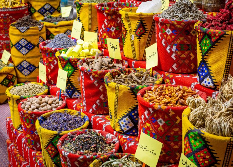 Colorful bags of spices and herbs at a local market visited on luxury Oman tours.