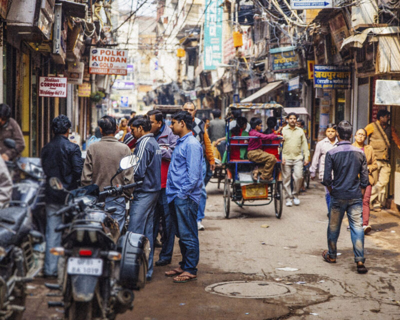 Old Delhi rickshaws are seen scattered down a busy Dehli street.