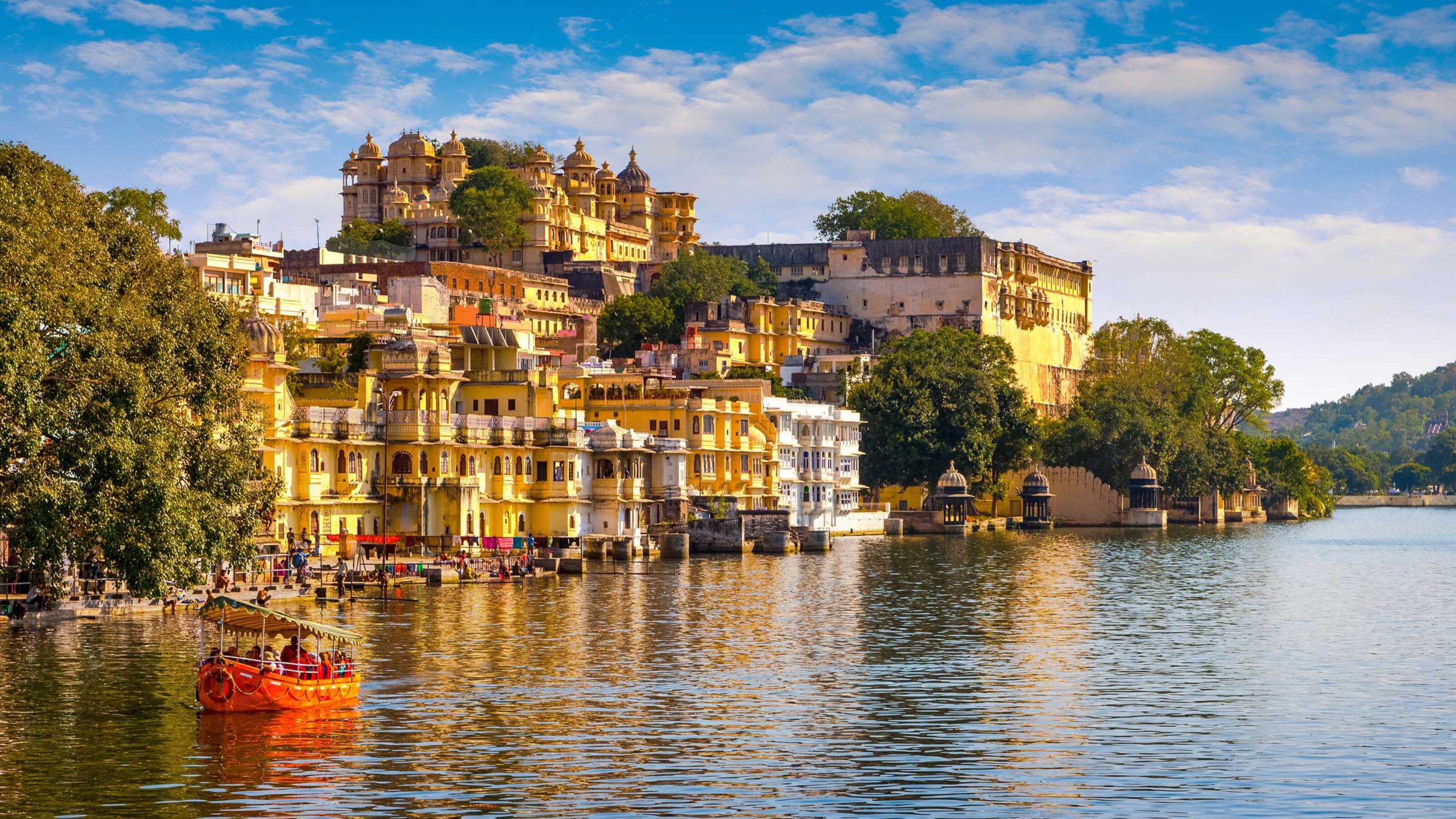 Udaipur city, with colourful buildings on the banks of a wide blue river