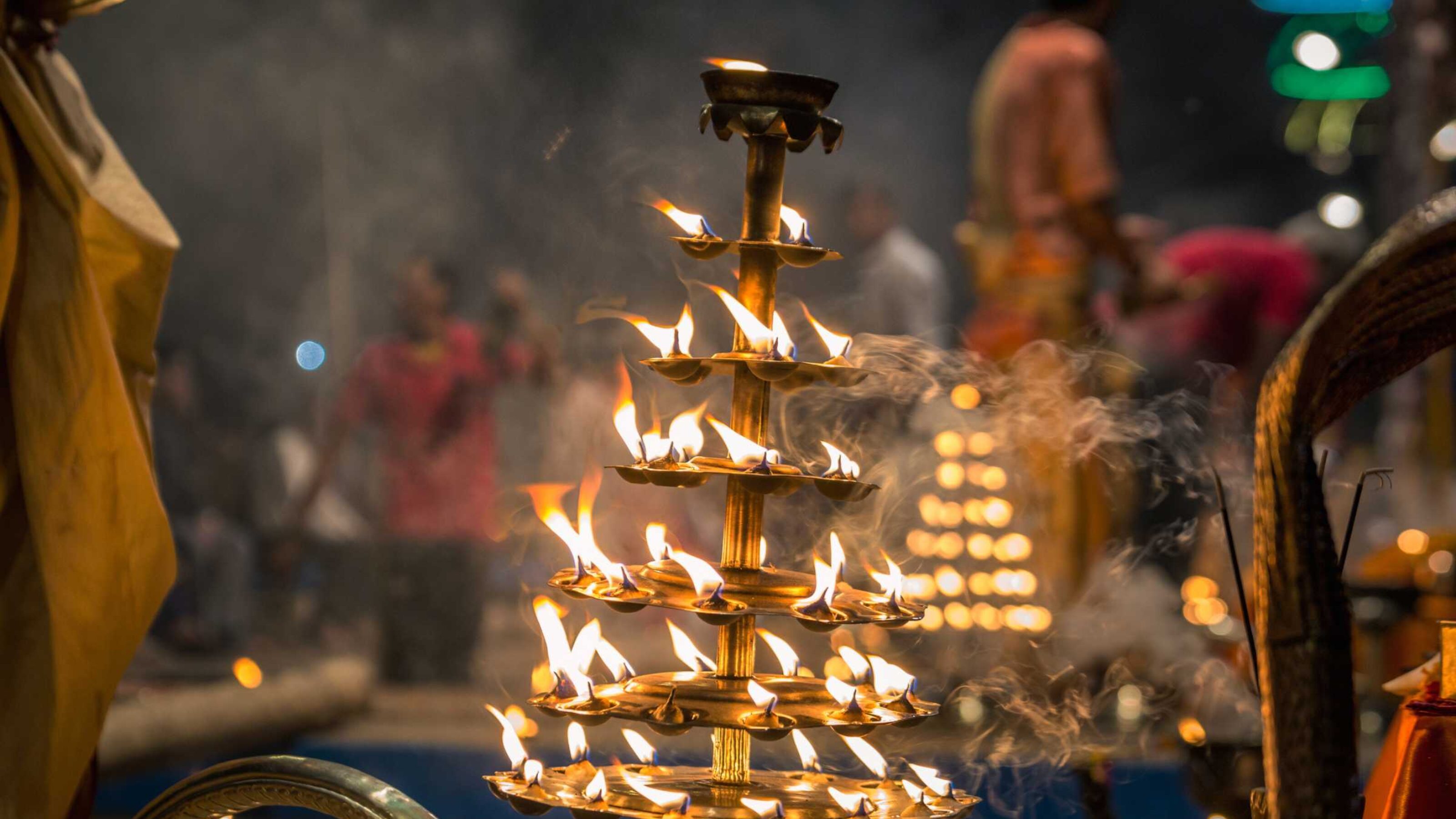 A multi-level metal structure with platforms for tea lights, which are burning