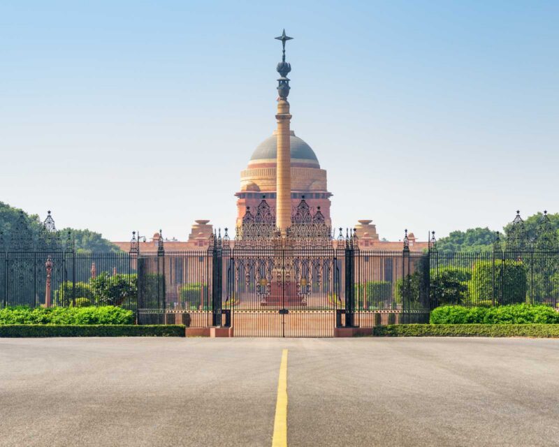 The grand dome of Rashtrapati Bhavan stands tall against a clear blue sky in New Delhi, India.