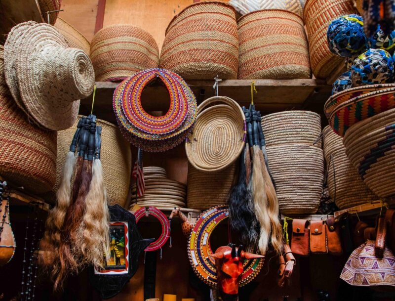 Arusha,Tanzania, Africa.02 february 2022. African masks, beaded bracelets, necklaces, Tanzanian national clothes, bags woven from natural material displayed and ready for sale. Calendars and tourism