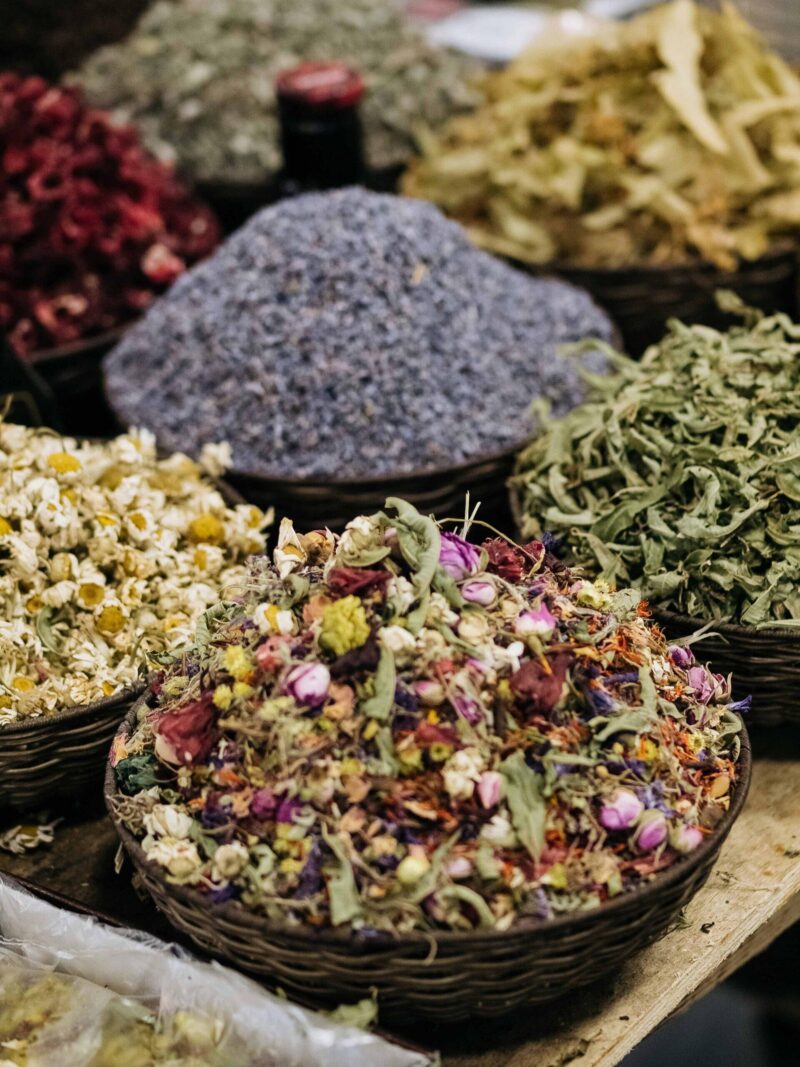 Mounds of dried herbs, lavender and loose-leaf teas displayed in woven baskets at a bazaar in Baku, Azerbaijan.
