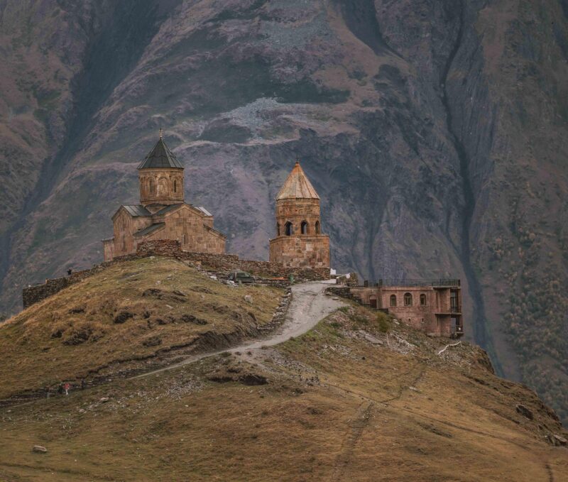 A Mesmerizing view of an old church on the top of a hill in Kazbegi National Park in Georgia