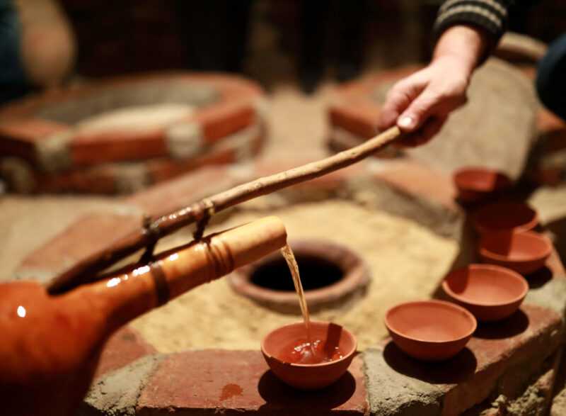 Person pouring wine from qvevri using Orshimo