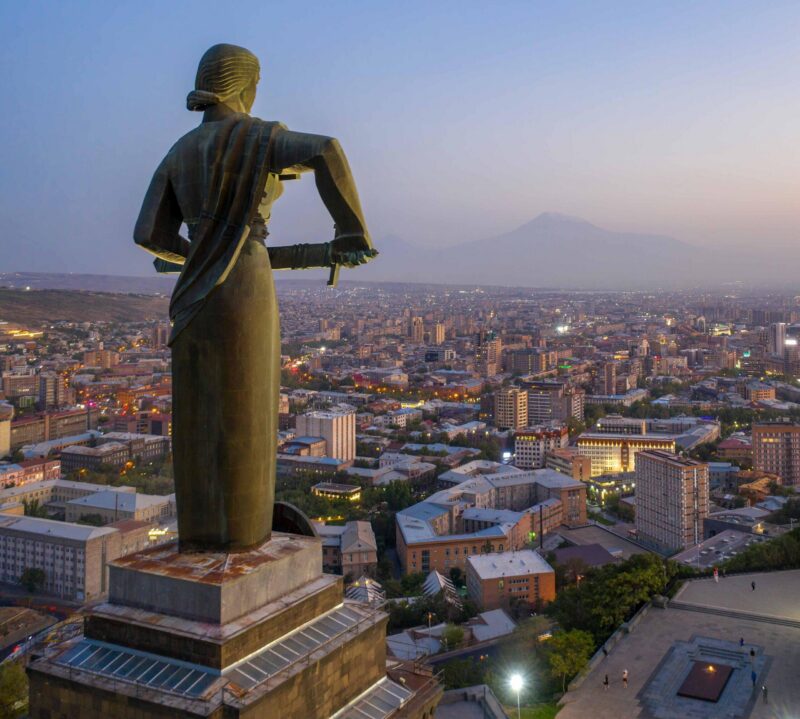 View of Mother Armenia Statue, Eternal Fire in Akhtanak Park and the city in the evening. Yerevan, Armenia.