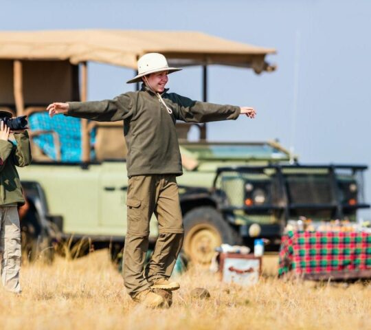 Children play after a bush breakfast while on safari