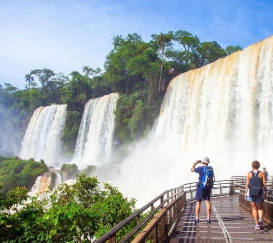 Visitors walk close to the cascading waters of Iguassu Falls